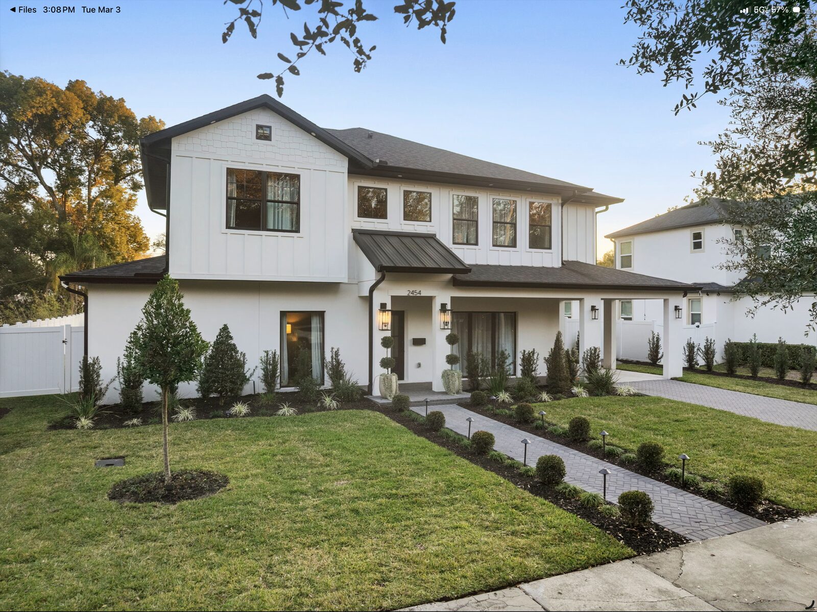 Modern white farmhouse photographed at twilight