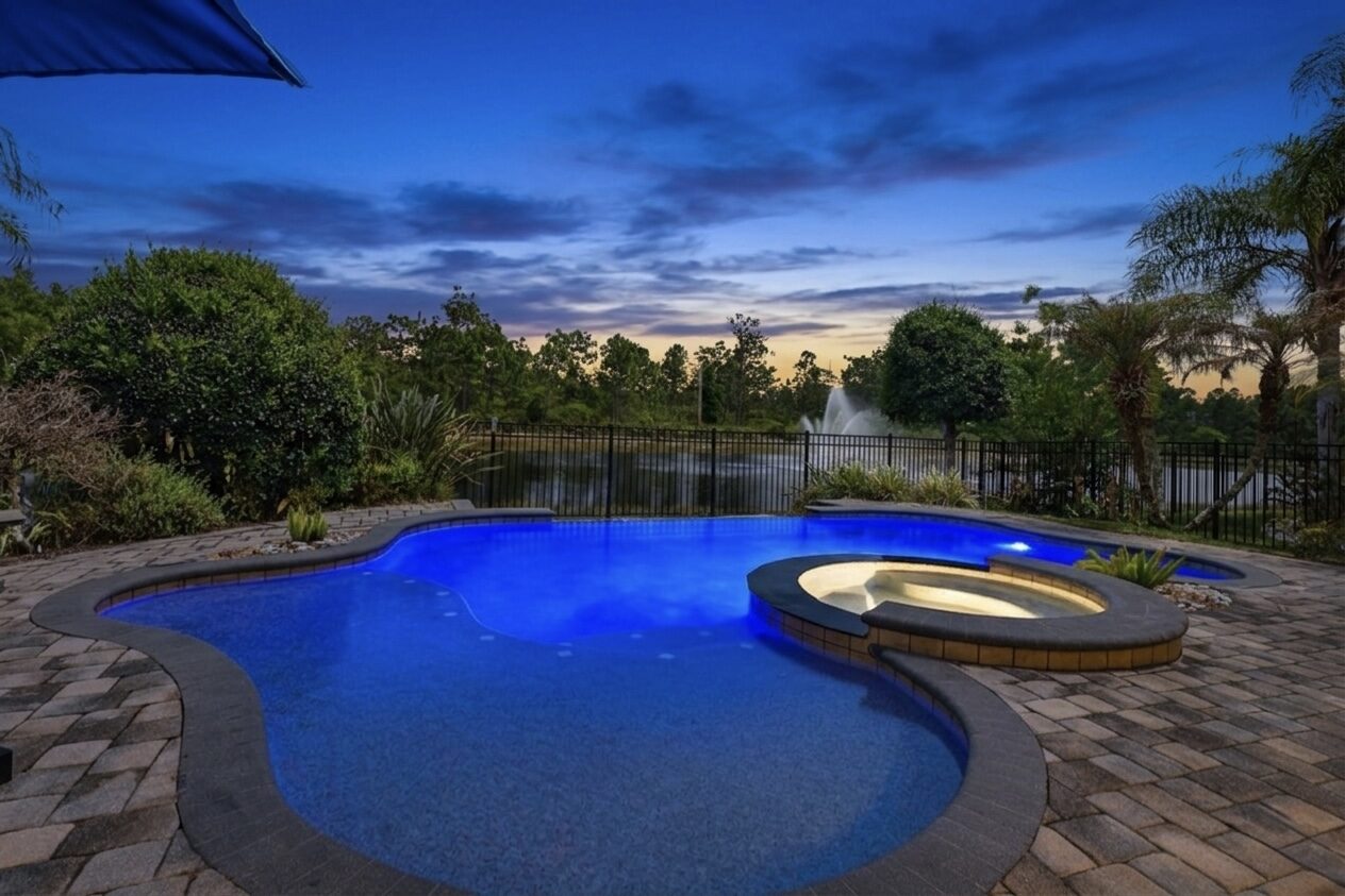 Pool and spa at twilight beside a lake
